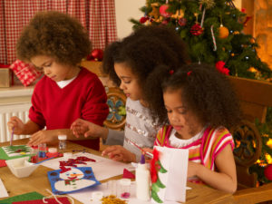 Children making Christmas cards at a table together