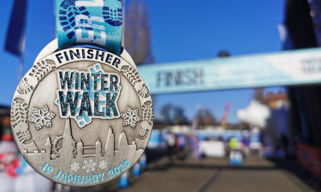 The medal you receive when you complete the Winter Walk, with the finish line in the background.