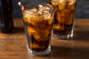two soft drinks with ice and a straw