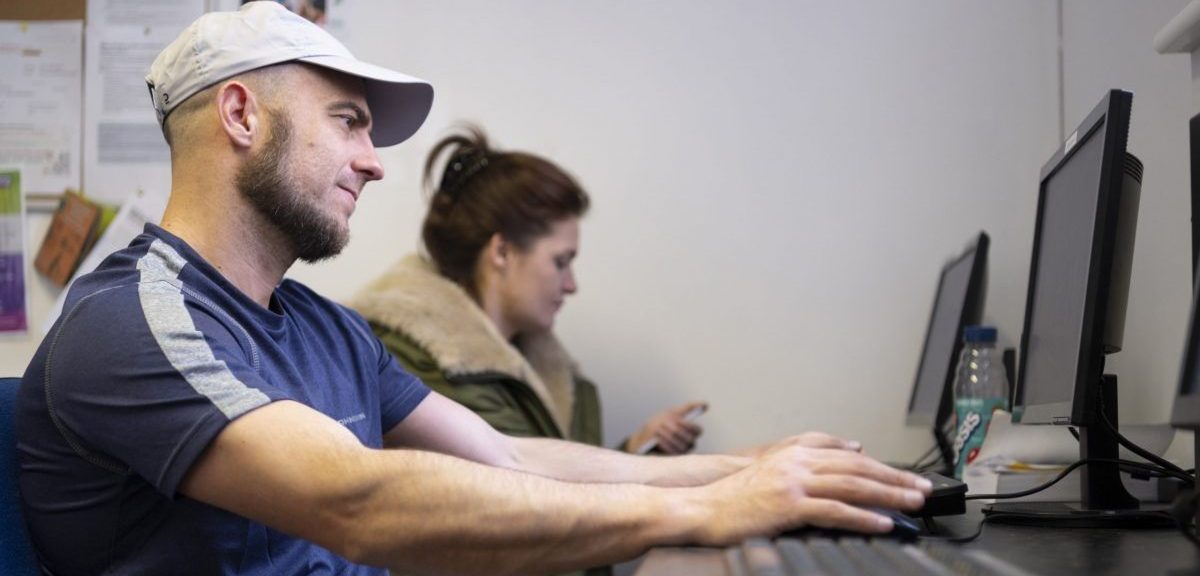 Two people working on a computer in an office