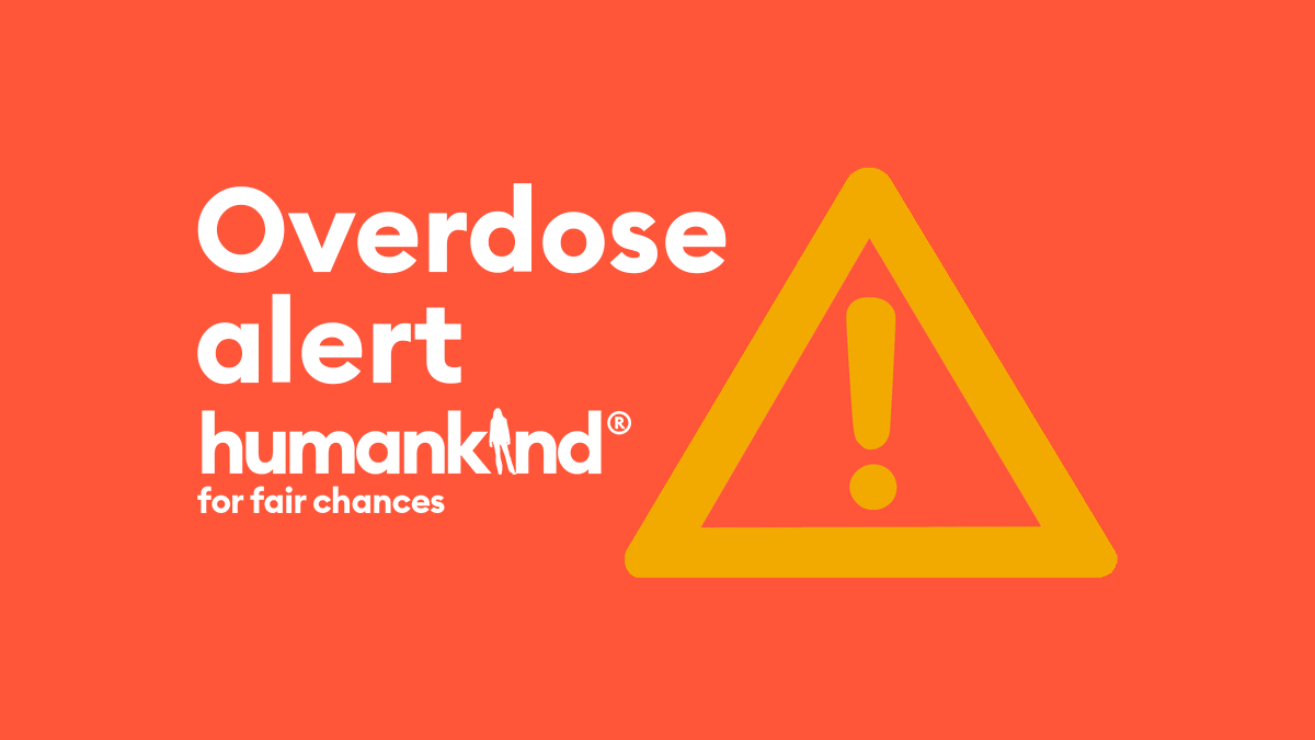 A red graphic with the text "Overdose alert". An orange warning sign appears to the right of the text and the logo the Humankind logo appears below.