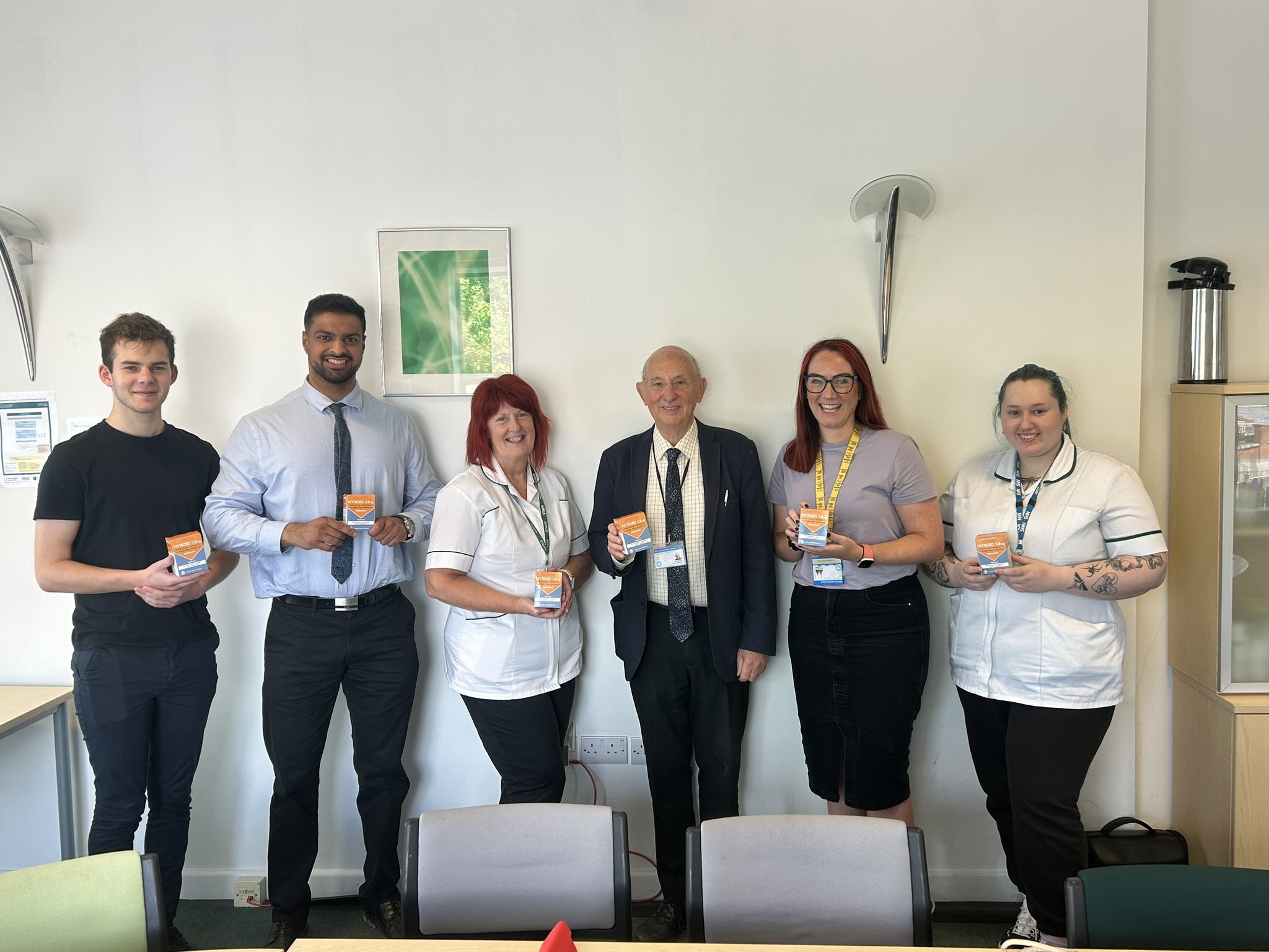 Wicker pharmacy staff holding naloxone kits after being trained to use them