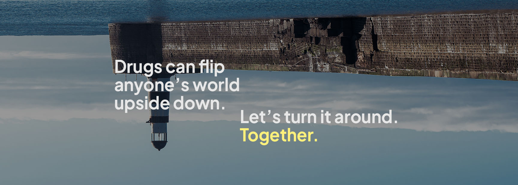 An image of a pier and a lighthouse stretching out to sea is turned upside down. The text says 'Drugs can flip anyone's world upside down. Let's turn it around together."